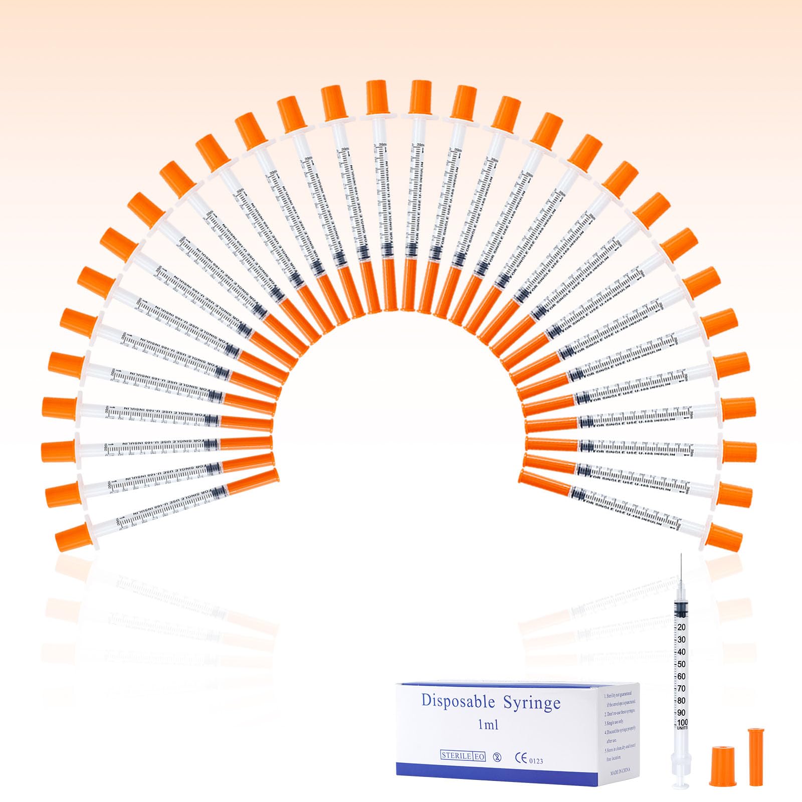 Séringues jetables avec aiguilles, corps gradué et capuchons orange autour d’un pack.